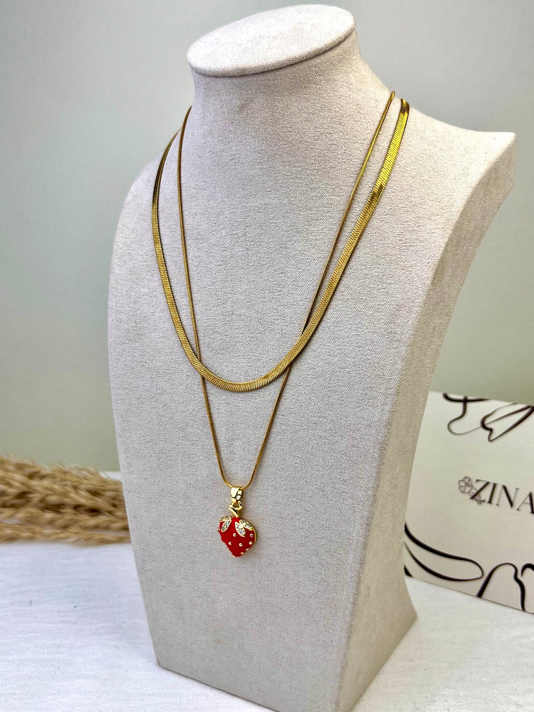 Two-tiered necklace with a red strawberry pendant