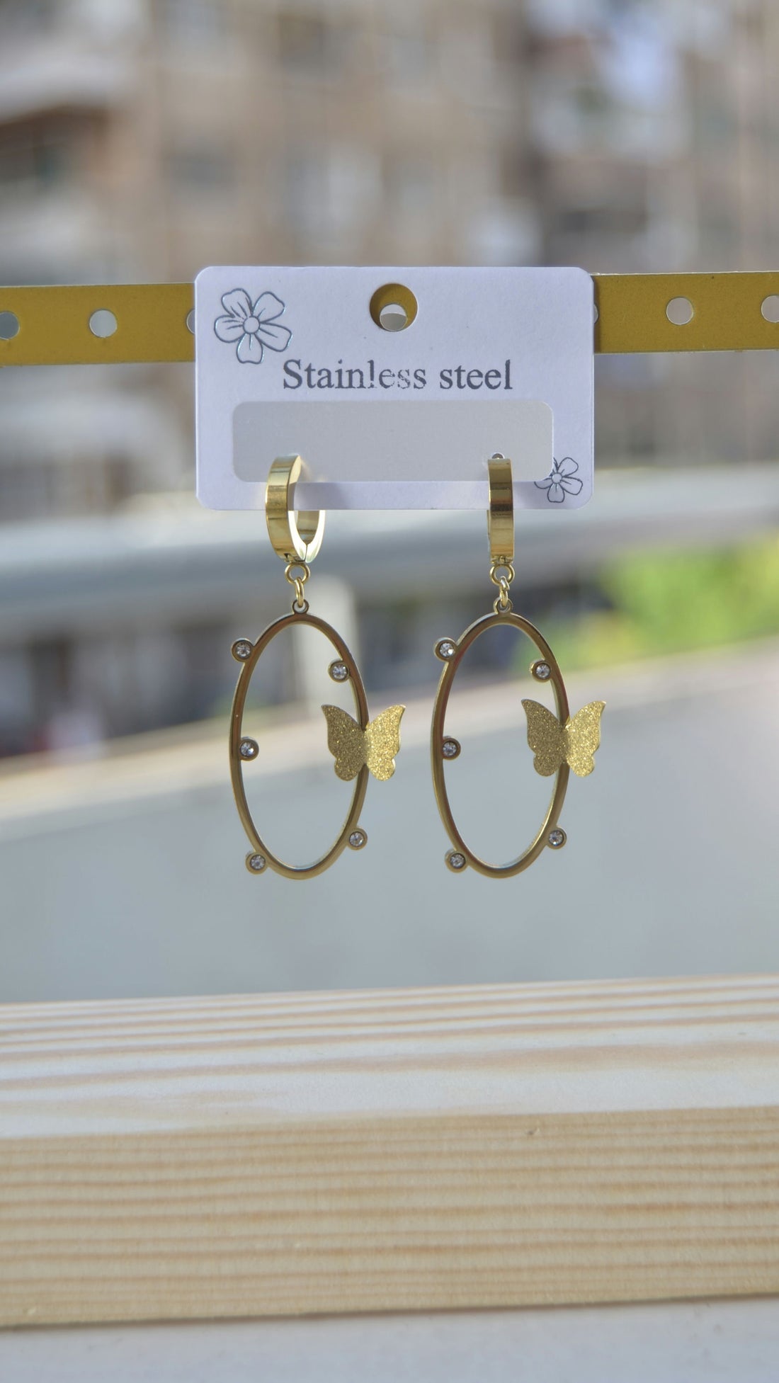 Oval earrings with a studded butterfly